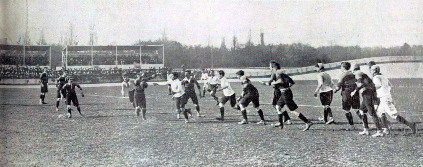 Une charge d'avants lors d'un match de rugby en 1910, devant une tribune pleine